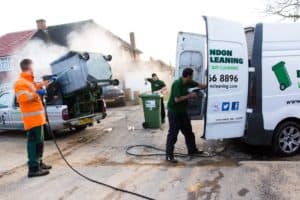 A group of men performing exterior cleaning on a van in front of a house. Passover,