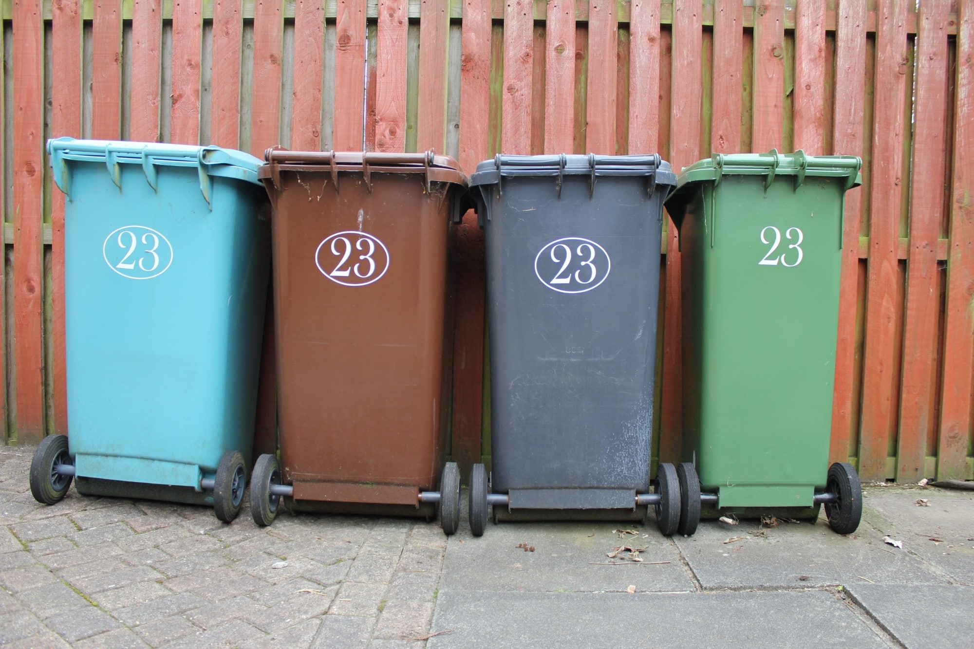 bin cleaning, Four wheeled trash cans lined up in a row for exterior cleaning.