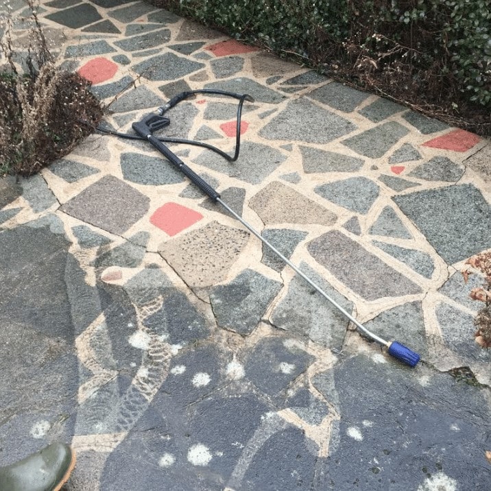 A shovel is laying on a stone walkway.
