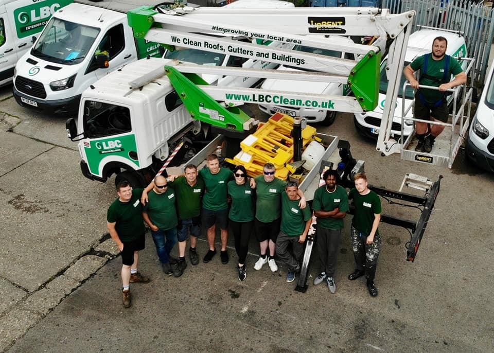 A group of people standing in front of a group of trucks for Commercial Cleaning purposes.